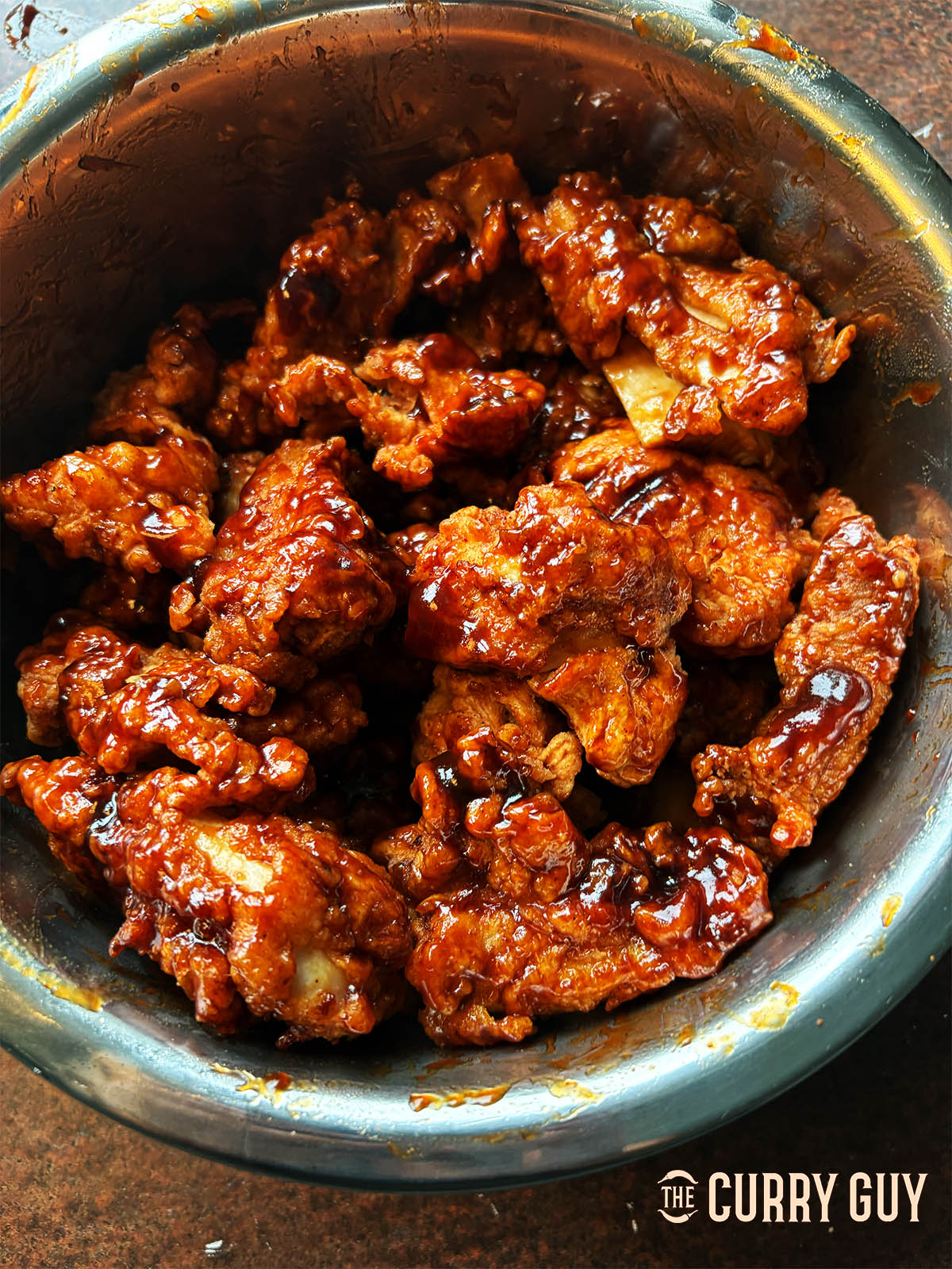 Tossing the chicken with the barbecue sauce.