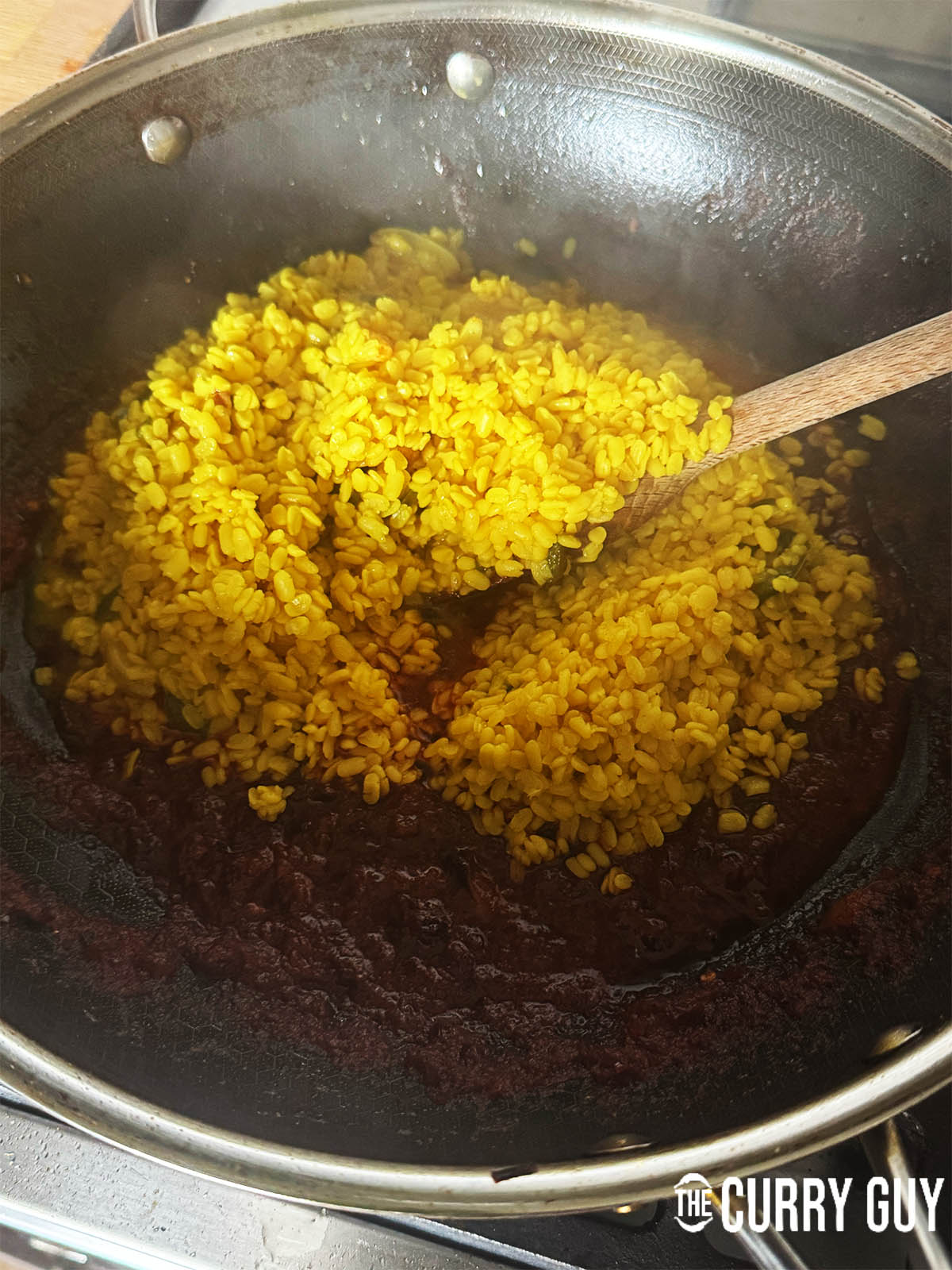 Adding the lentils to the base masala.