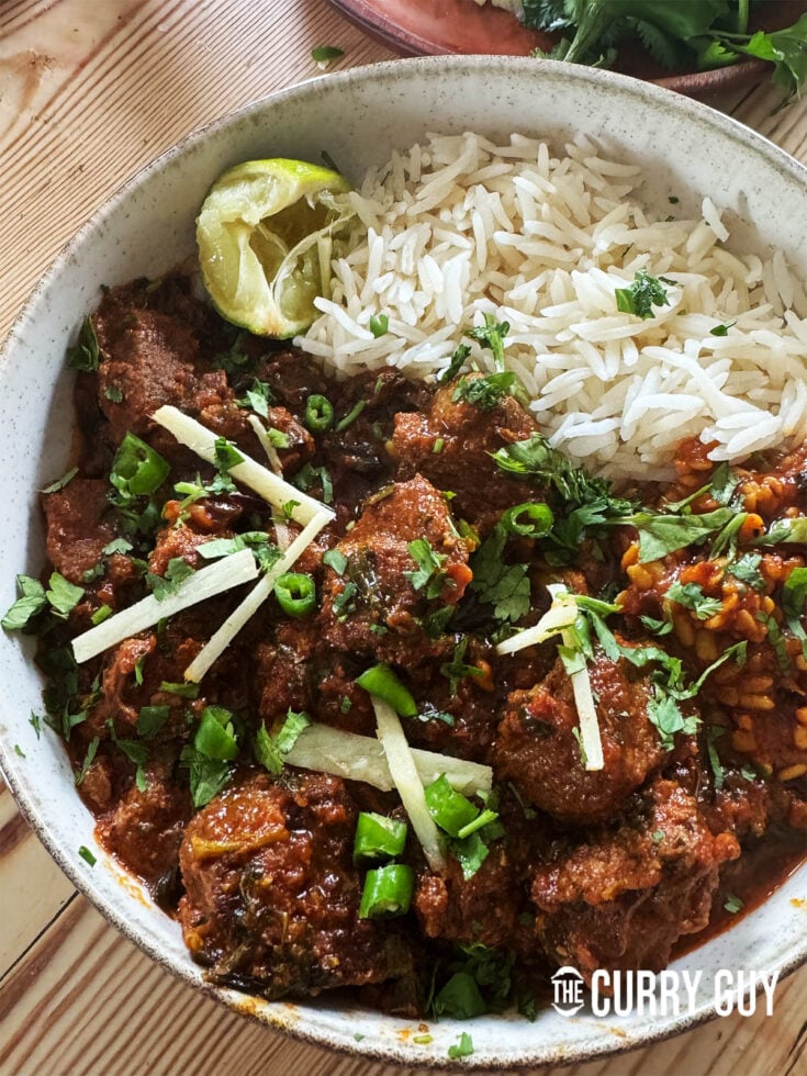 Serving the lamb methi curry topped with julienned ginger, lemon wedge, coriander and chillies.
