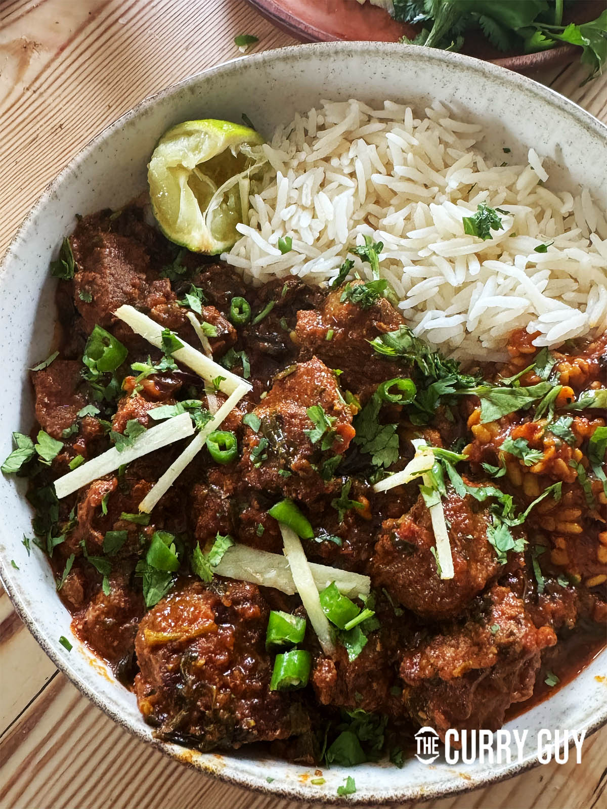 Serving the lamb methi curry topped with julienned ginger, lemon wedge, coriander and chillies.