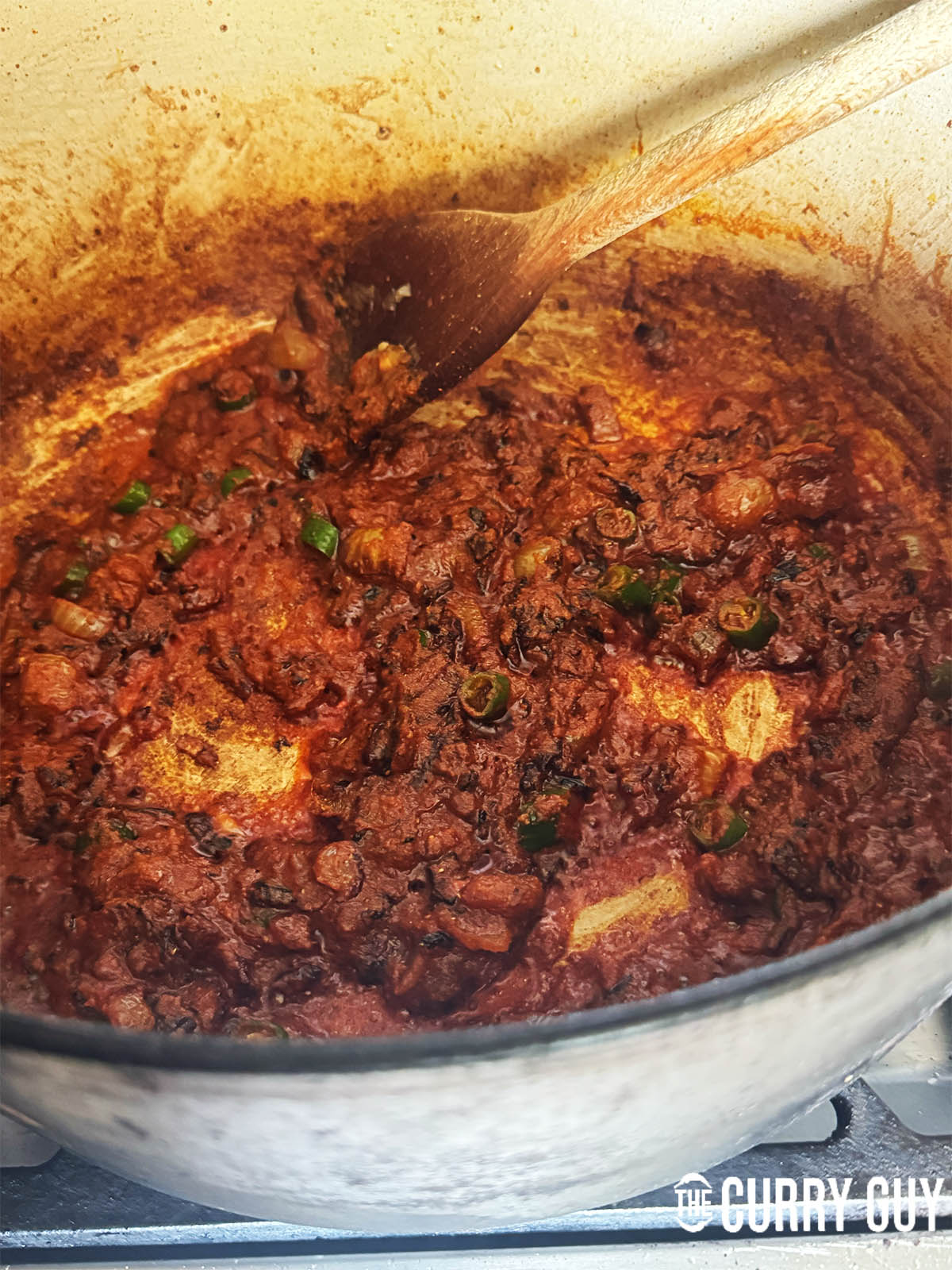 Adding the ground spices to bloom them into the oil. Then adding water so the spices don't burn.
