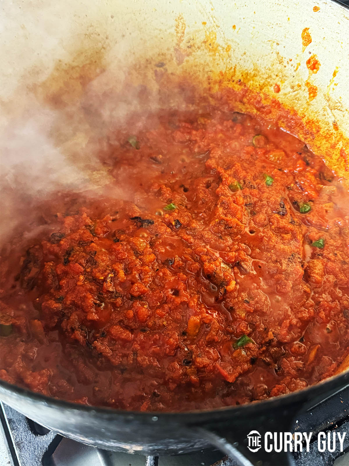 Adding and then simmering the chopped tomatoes for 10 minutes.