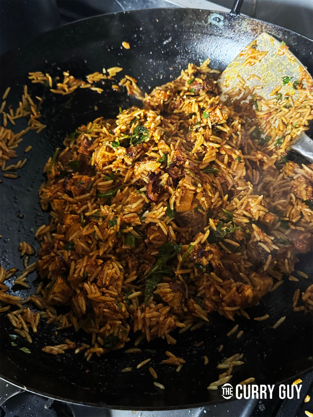 coating the rice in the chickne tikka biryani flavours