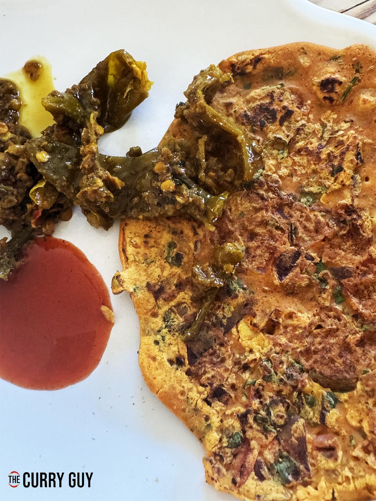 A chilla served with chutneys.